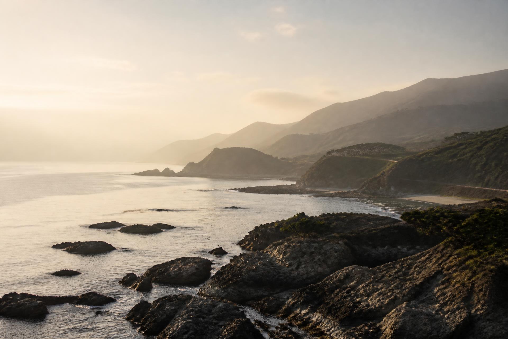 Japanese coastline at dawn with misty mountains over a calm ocean